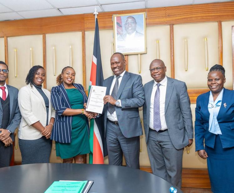 Mr. Josiah Musili, EBS and RELI Africa Kenya Coordinator, Ms. Nyambura Thiong'o, display the signed MOU during the partnership signing event.